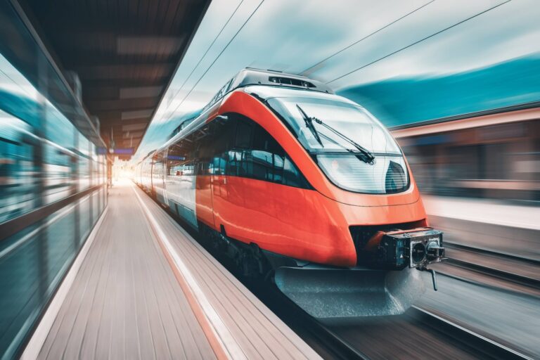 high speed orange train in motion on the railway station